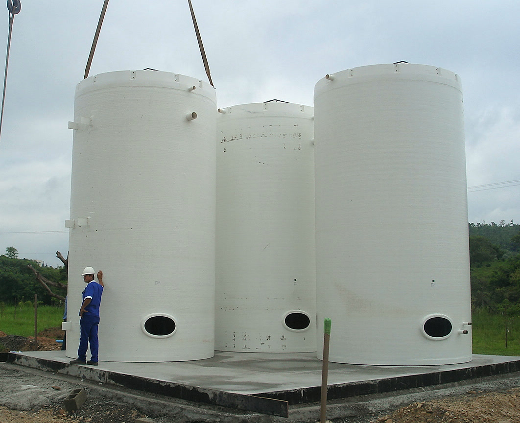 Três reatores verticais em PRFV instalados sobre base de concreto, com operário ao lado dando a escala — Global Ecosolutions