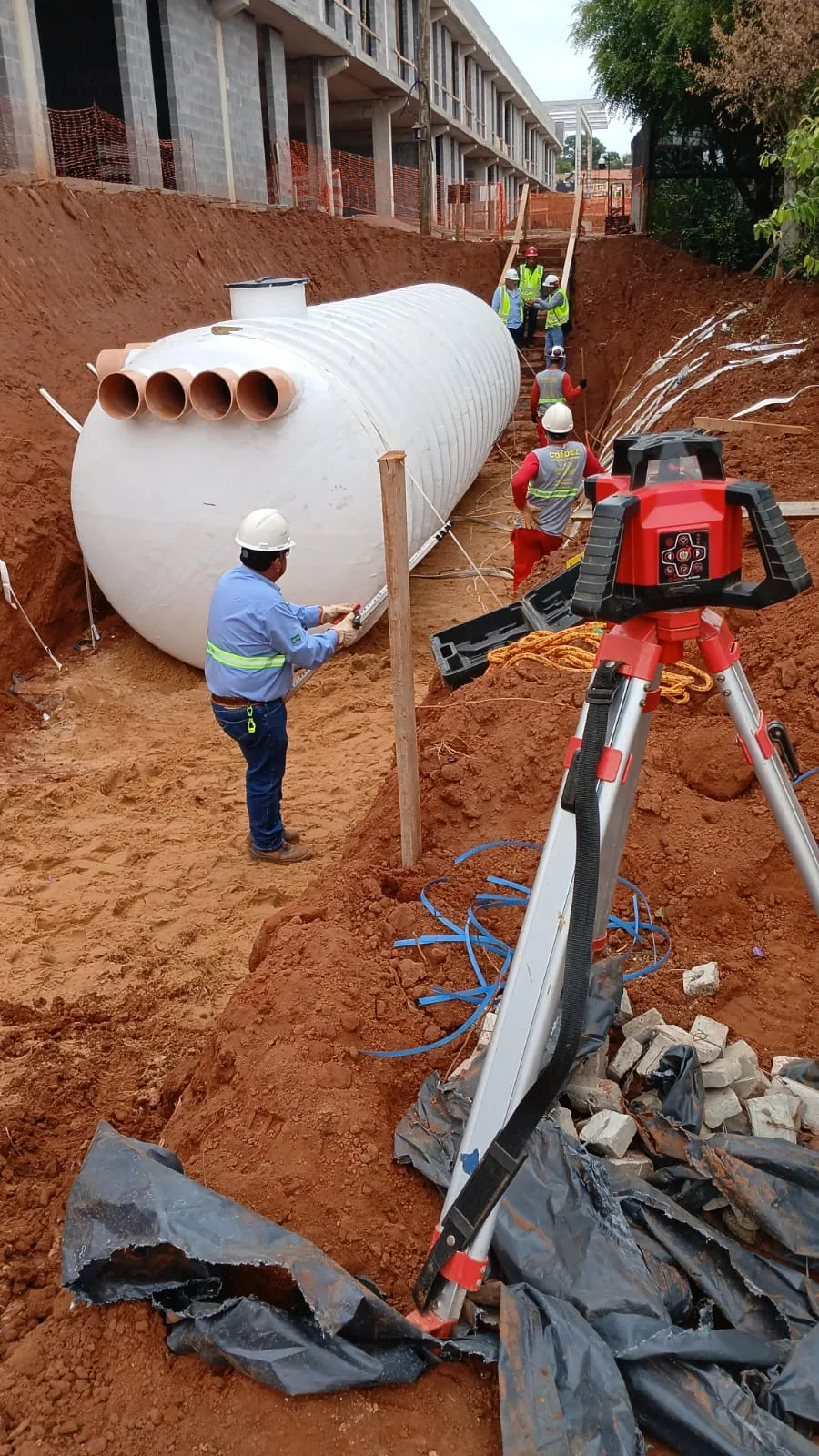 Cisterna Pronta 60,000 L for rainwater retention at a São Paulo State public school site — leveling in the trench